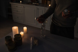 in a grid-down scenario, a man lights candles in the kitchen