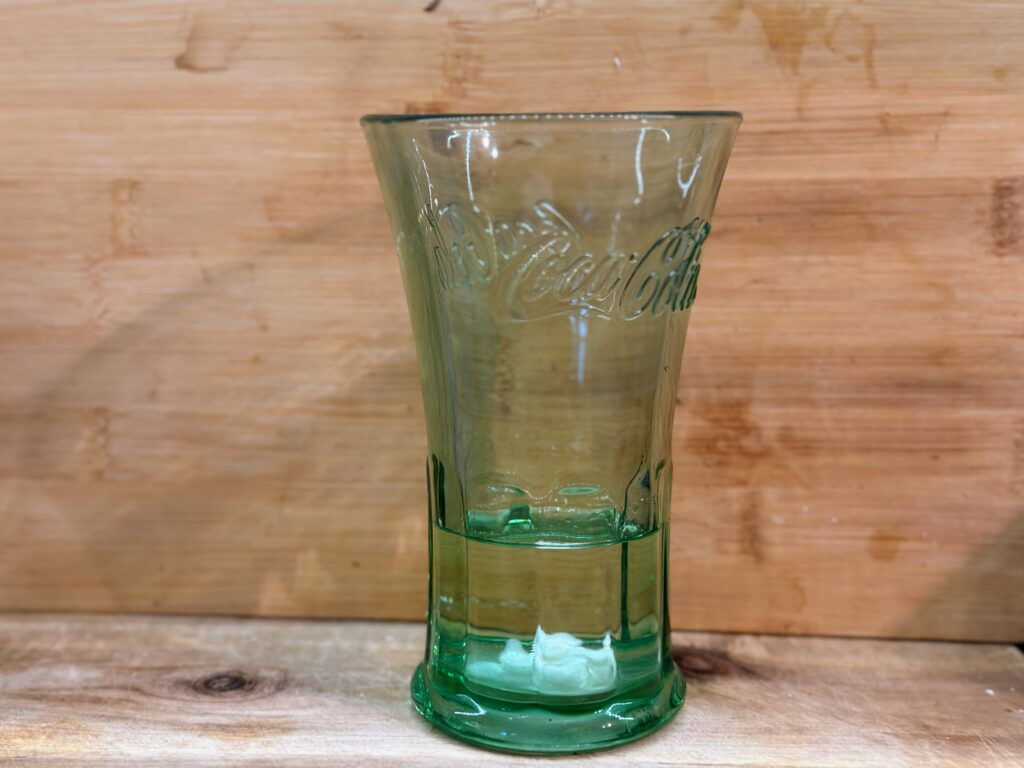 A glob of sourdough starter in a green glass