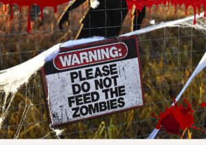 Sign that says "Warning: Please Do not Feed The Zombies." Zombie survival kit.
