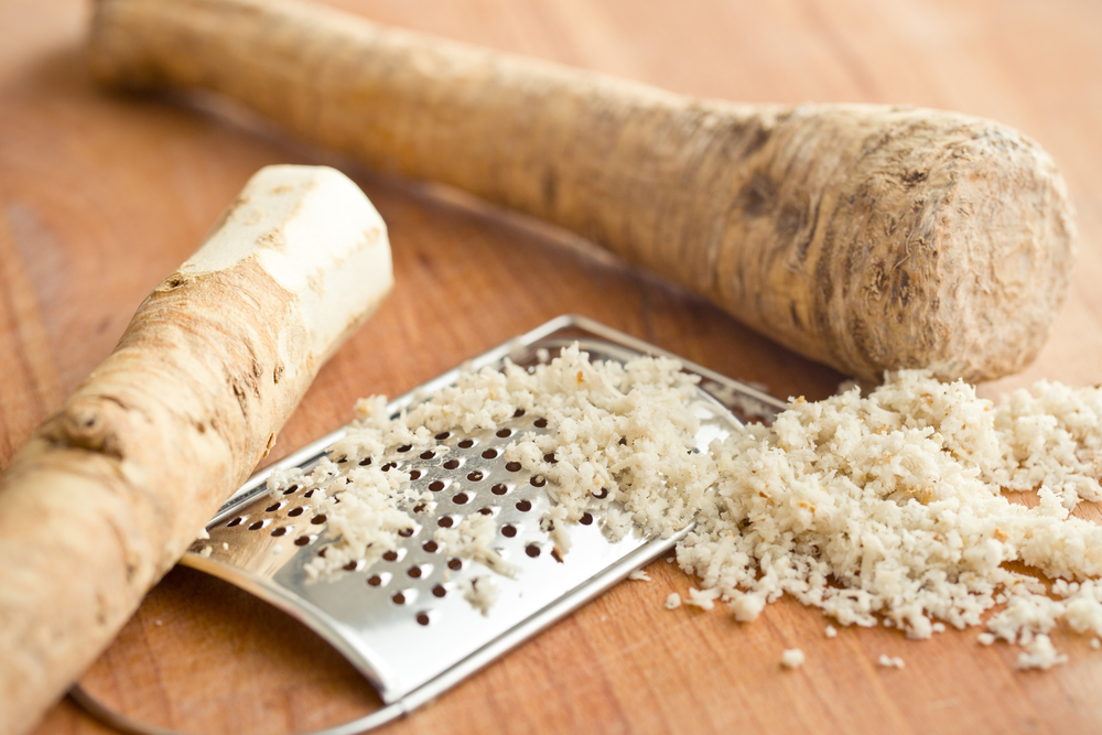 Grated horseradish on kitchen table, with grater